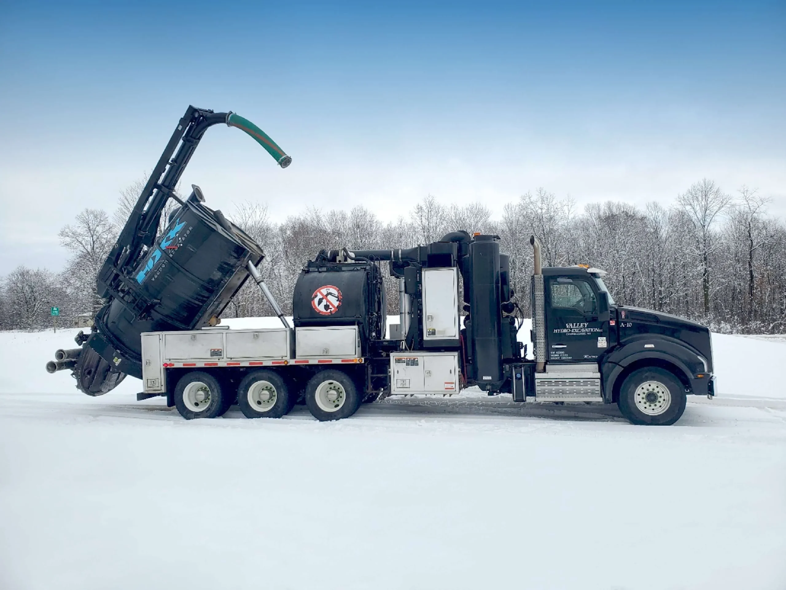 a black excavation truck on the snow in winter